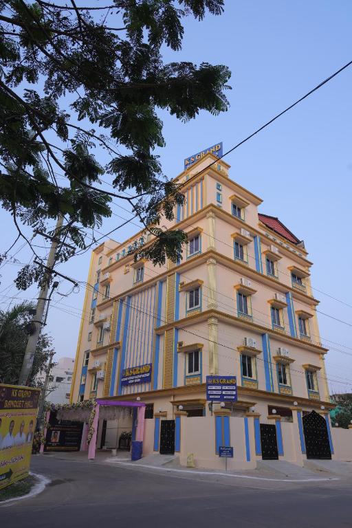 a large yellow building with blue windows on a street at ks grand function hall in Jāmb