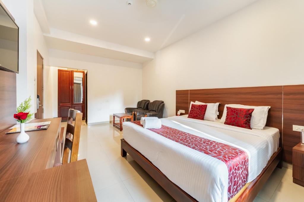 a hotel room with a large bed and a desk at Hotel Sandra Palace in Thekkady