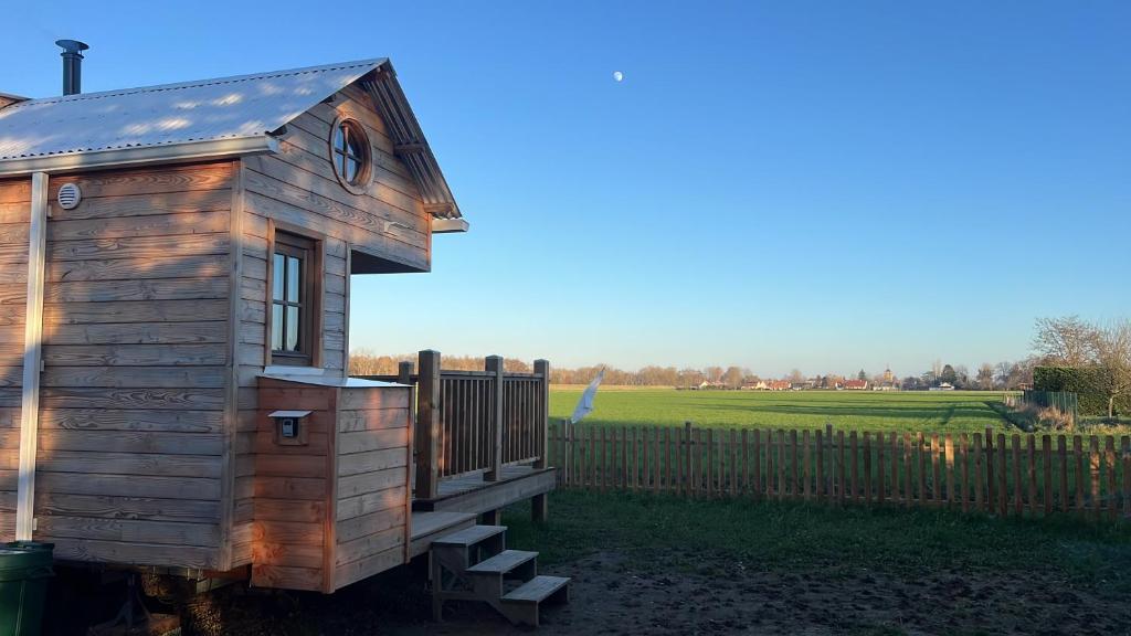 a tiny house in a yard with a fence at Tiny House chez Annette in Darvoy