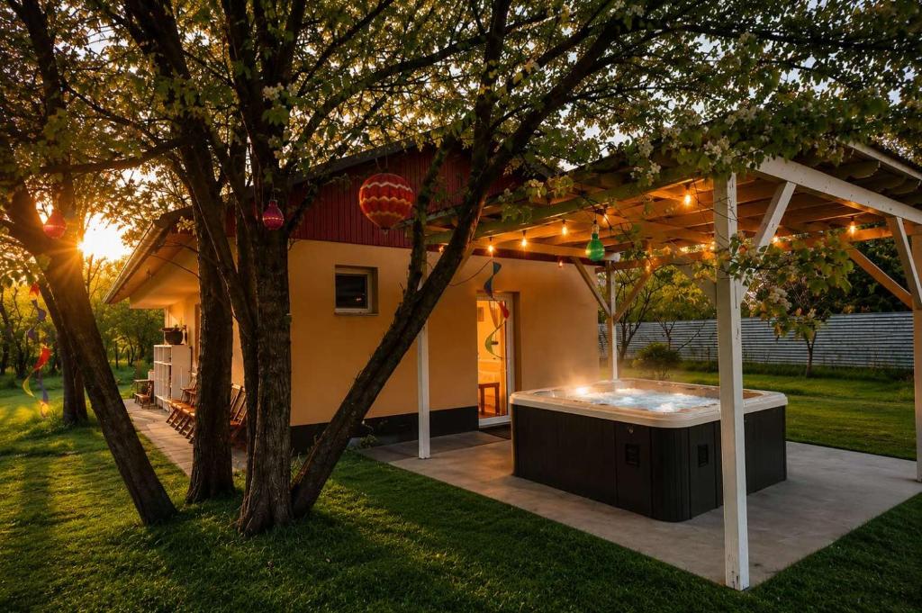 a backyard with a hot tub under a pergola at Varázslakos Tanya in Soltvadkert
