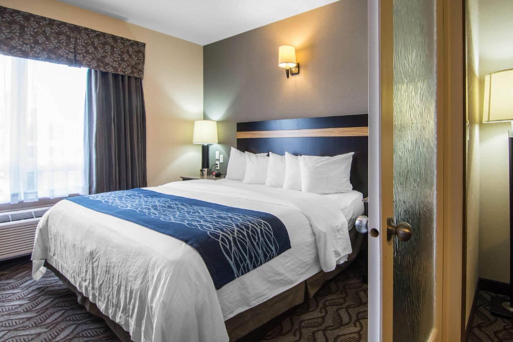 a hotel room with a large bed and a window at Comfort Inn & Suites in Fort Saskatchewan