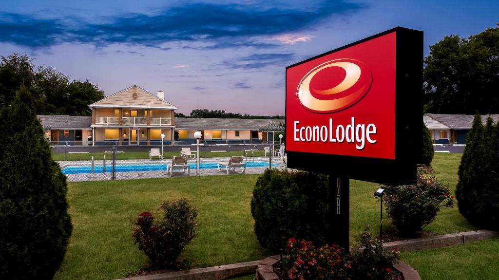 a sign in front of a house with a pool at Econo Lodge Palmyra - Hershey in Palmyra