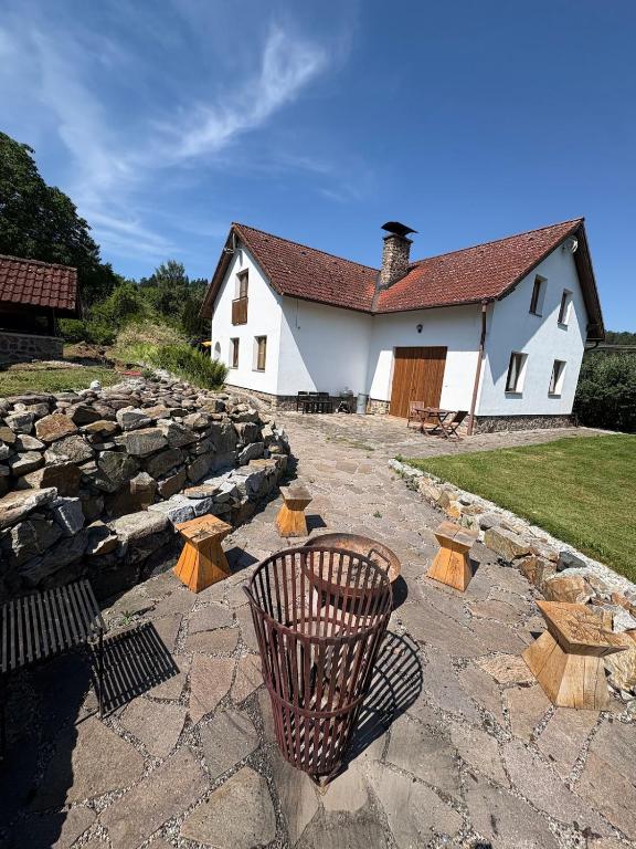 a building with a stone wall and a trash can at Šumavský dům in Drslavice