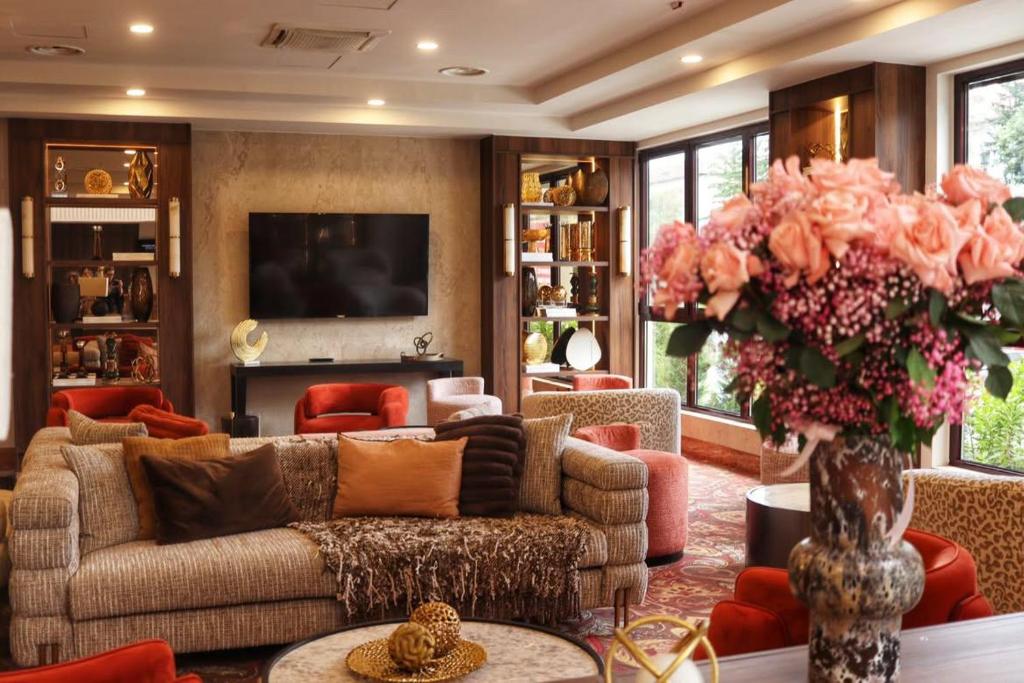 a living room with a couch and a vase of flowers at Hotel Rivo Timisoara in Timişoara