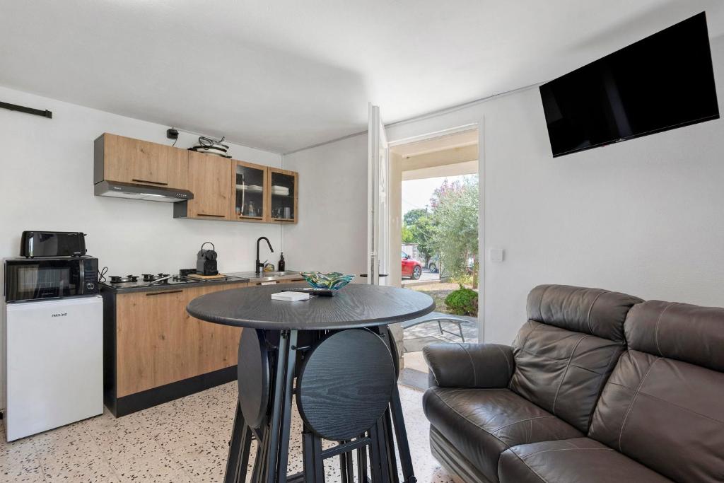 a kitchen and living room with a table and a couch at les Iris in Pont-Saint-Esprit