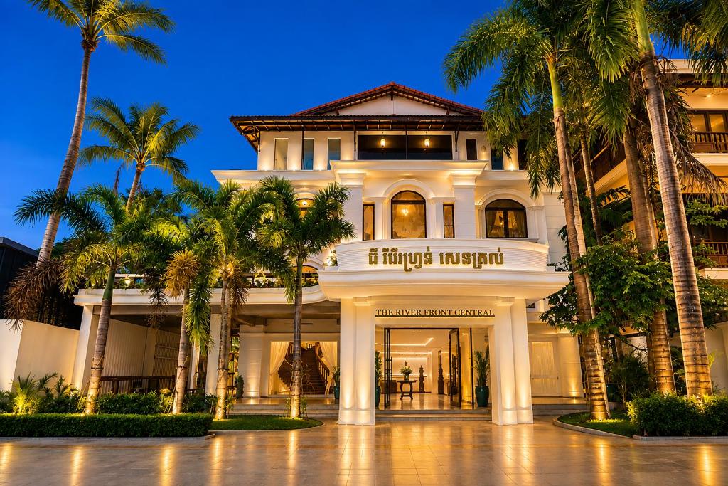 a building with palm trees in front of it at THE RIVERFRONT CENTRAL Hotel in Siem Reap