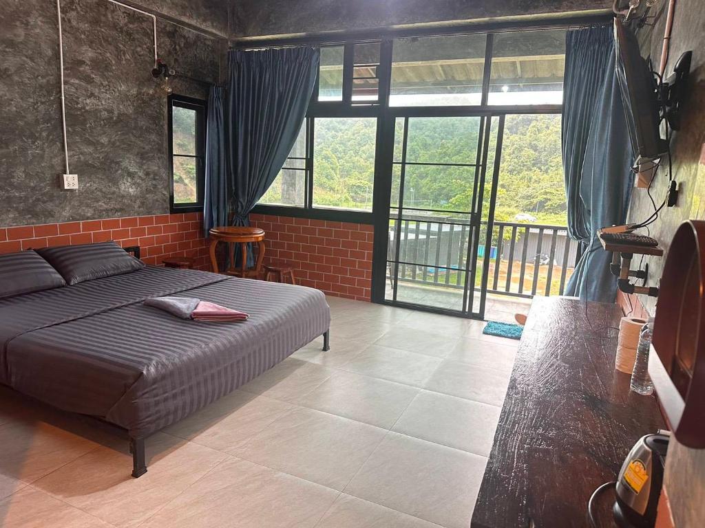 a bedroom with a bed and a large window at Love Loft Homestay in Ban Pilok Khi