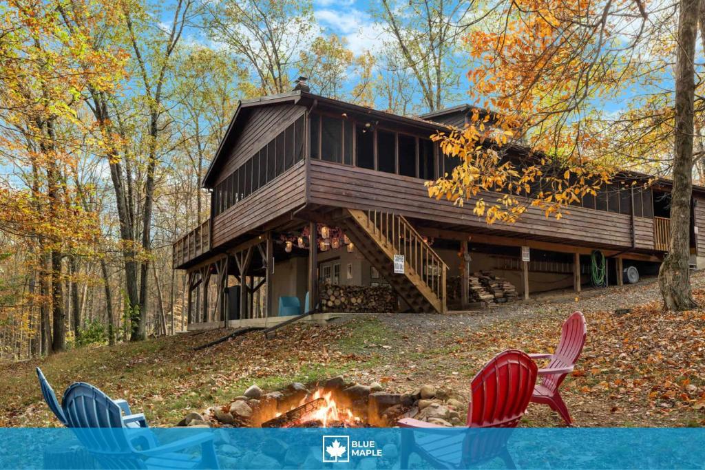 a house with chairs and a fire in front of it at Hot Tub, Deck, Grill, Fire Pit, Game Room & WiFi in Great Cacapon