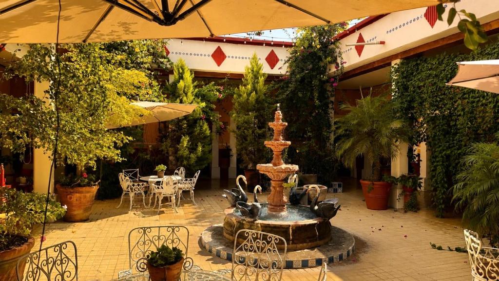 ein Brunnen in einem Innenhof mit einem Tisch und Stühlen in der Unterkunft Copa de Oro Hotel Boutique in Mascota