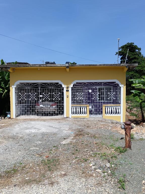 a yellow house with two gates in front of it at 25 Spice in Port Antonio