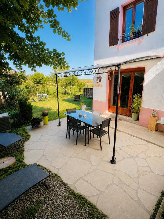 a patio with a table and chairs in front of a building at Gîte de Jean-Benoit in Le Passage