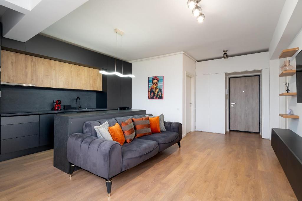 a living room with a couch and a kitchen at N31 Pipera Executive Apartment in Voluntari
