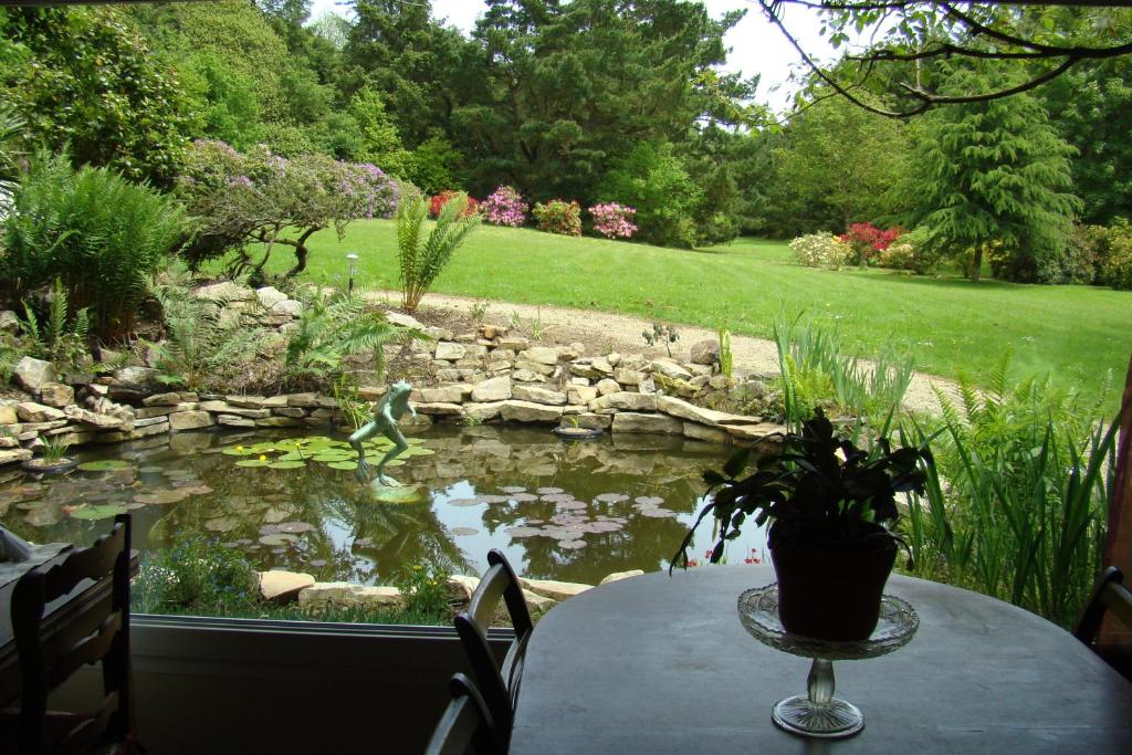 a table with a potted plant on top of a pond at Kernel Bihan in Pont-lʼAbbé