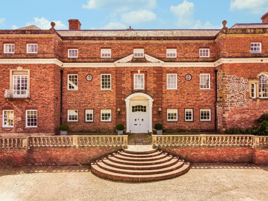 a large red brick building with a white door at Kyre Park in Tenbury