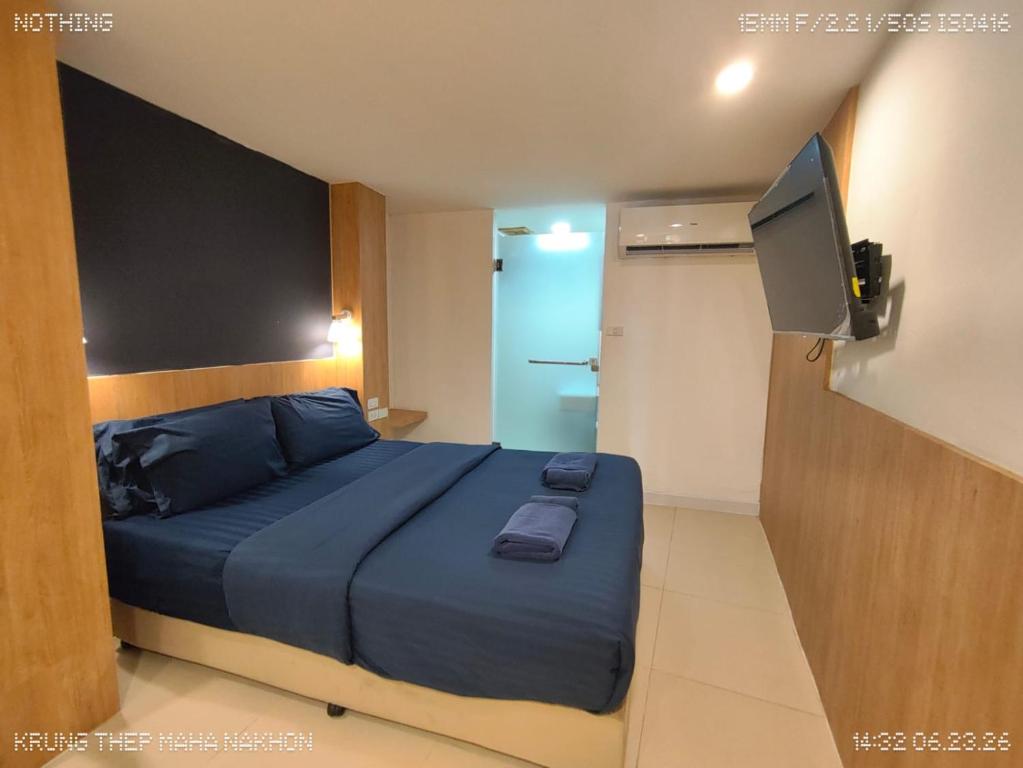 a bedroom with a blue bed and a television at GP House Express Sukhumvit 81 in Bangkok