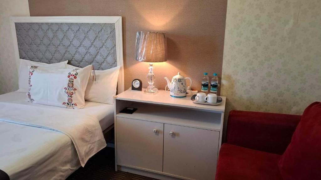 a hotel room with a bed and a table with a lamp at Crystal House Hotel in Buyant-Uhaa