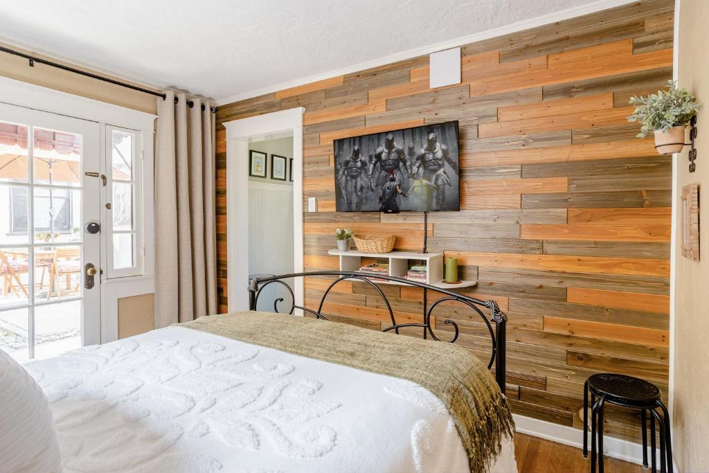 a bedroom with a wooden accent wall with a bed at Casita Gundry- Boutique Hideaway, Quaint Historic Charm in Long Beach