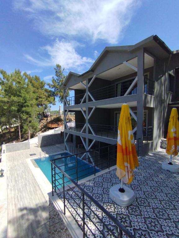a house with a swimming pool and two umbrellas at MAİ Sarıgerme in Sarigerme
