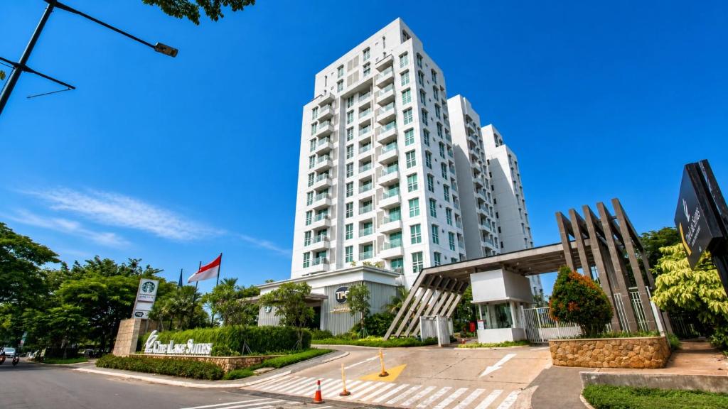 a tall white building in front of a street at Residencia Nova, Jakarta in Jakarta