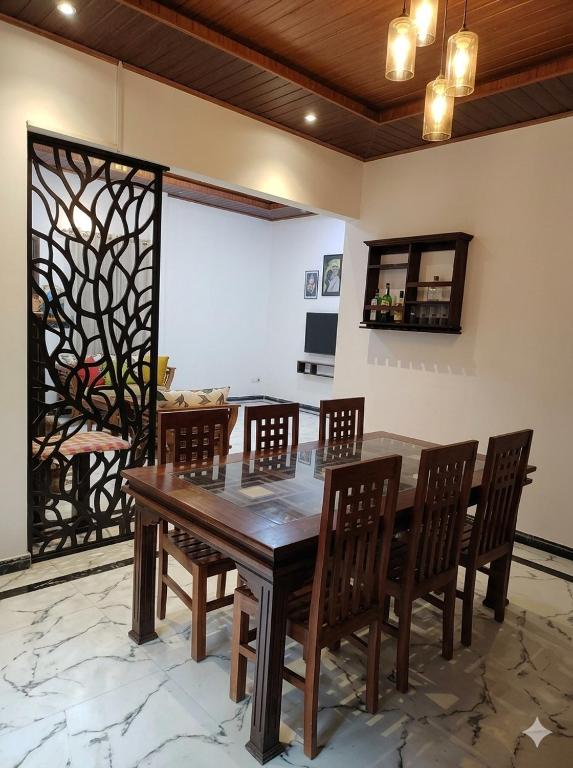 a dining room with a wooden table and chairs at CeylonAirbnb in Puttalam