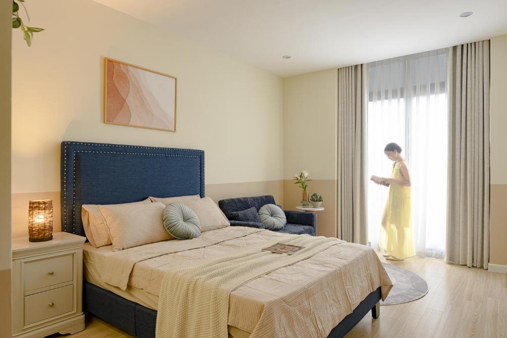 a woman standing in a bedroom with a bed at Amazing Studio Boutique Hotel in Hanoi