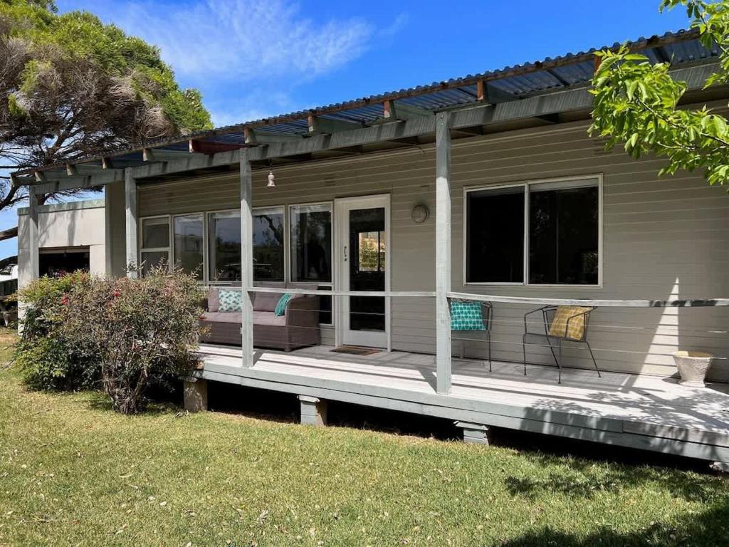 a small house with a porch and a yard at Barefoot Bungalow in Tomakin
