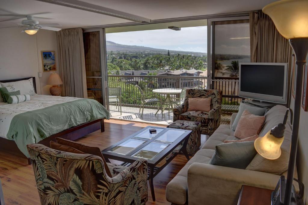 a bedroom with a bed and a living room with a tv at Mana Kai 710A in Wailea