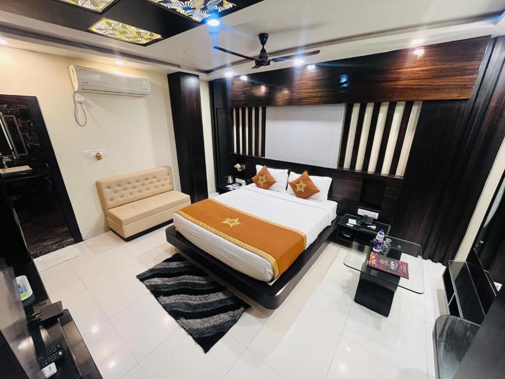 a bedroom with a bed and a couch in it at Hotel The Five Star Inn in Muzaffarpur