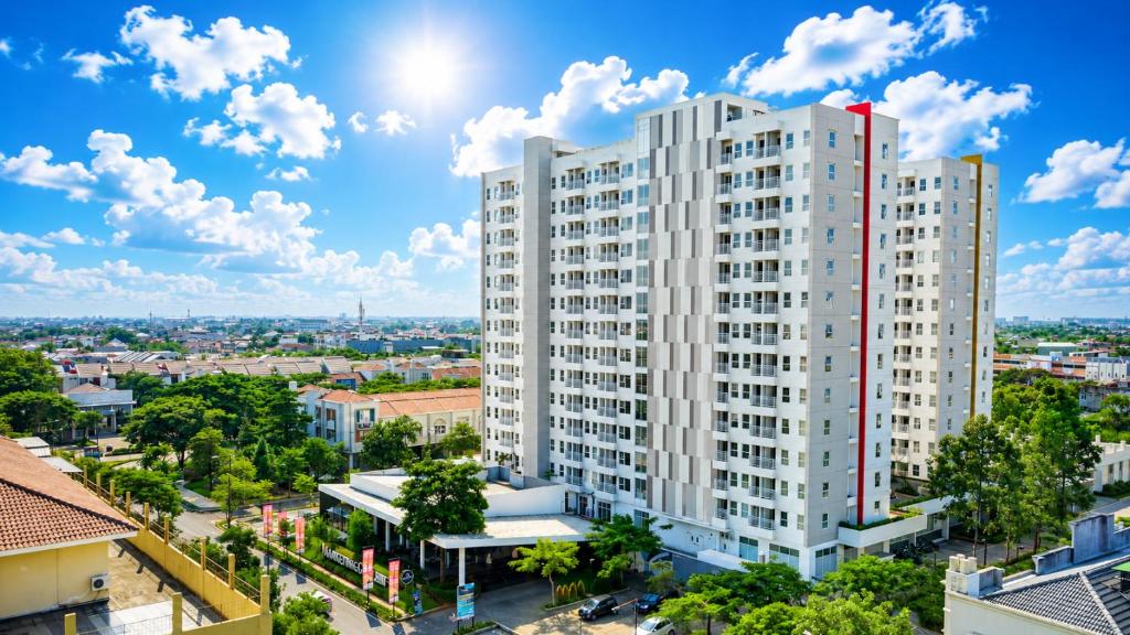 a tall white building in a city at Loft Privato, Jakarta in Jakarta