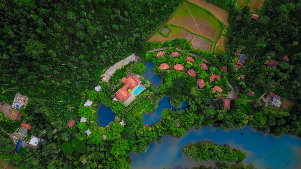 an overhead view of a park with houses and a lake at Kadkani River Resort Coorg in Siddapur