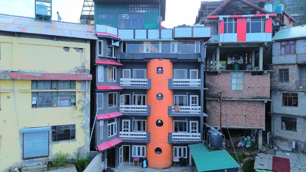 an apartment building with an orange building at Hotel Aman in Nārkanda