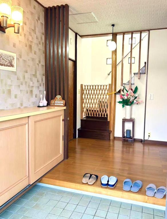 a lobby with two pairs of shoes on a wooden floor at 一棟貸切民宿Saisai 3部屋 in Sakai