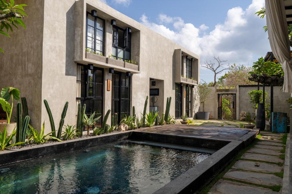 a house with a swimming pool in front of a building at Iron Wave Uluwatu in Bingin Beach