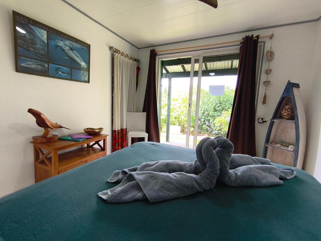 Ein Stofftier liegt auf einem Bett in der Unterkunft Te Ava Piti Lodge in Uturoa