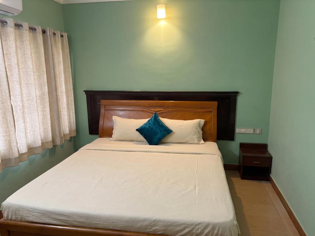 a bedroom with a bed with a blue wall at FabHotel City Inn in Hyderabad