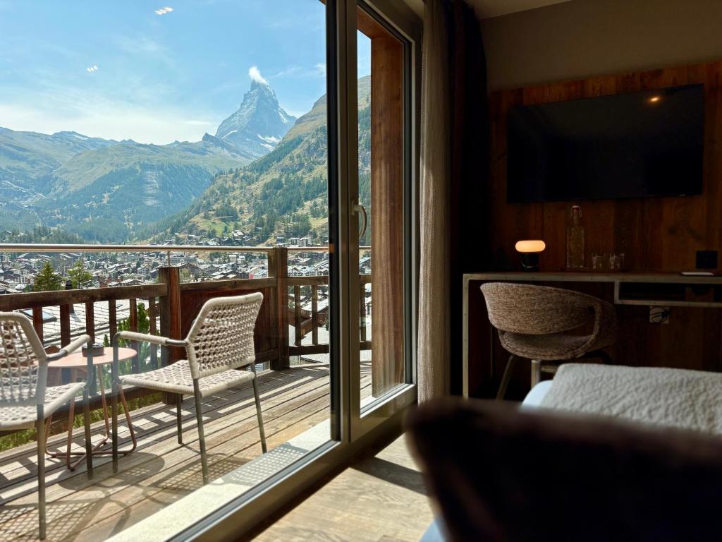 a room with a balcony with a view of a mountain at Alpenlodge in Zermatt