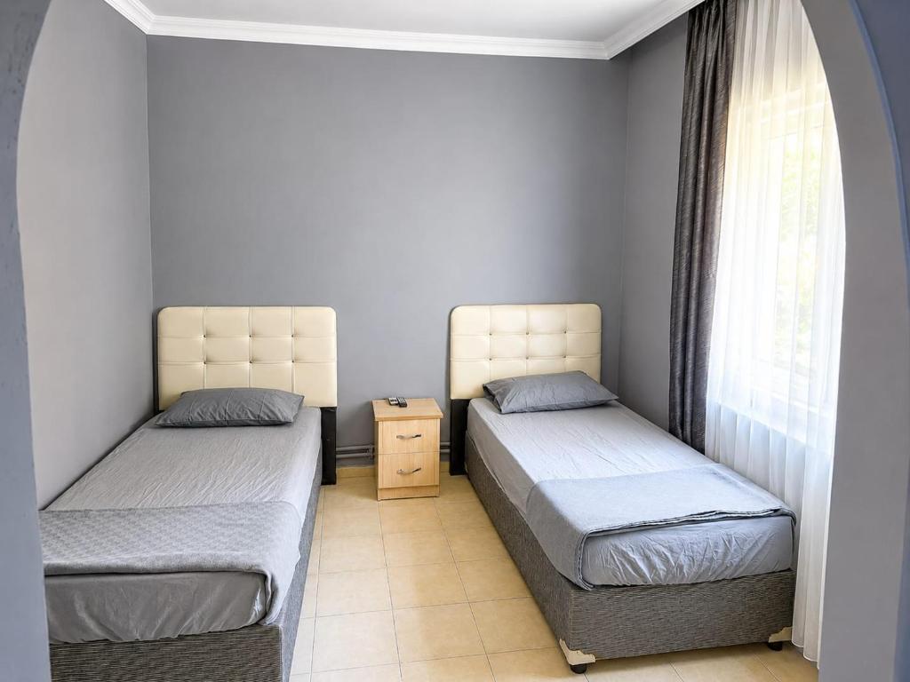 two twin beds in a room with a window at Ören örtur tatil evleri in Ören