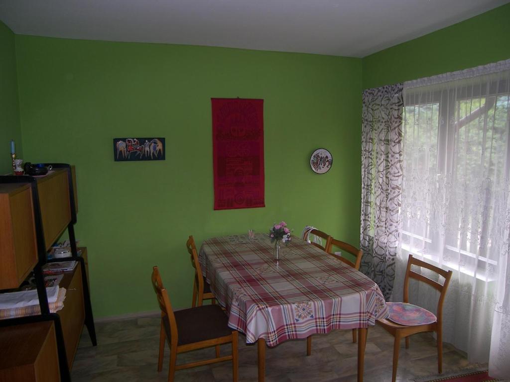 un comedor verde con mesa y sillas en Csilla Nyaraló en Tiszakécske