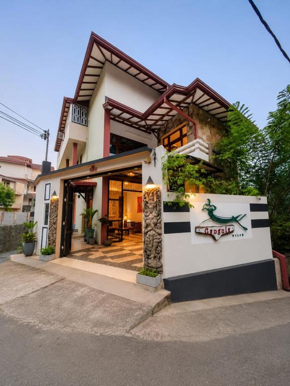 a house with a sign on the side of it at Gangula Villa in Kandy