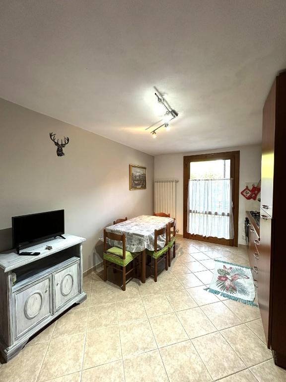 a living room with a table and a television at PINK House in Schilpario