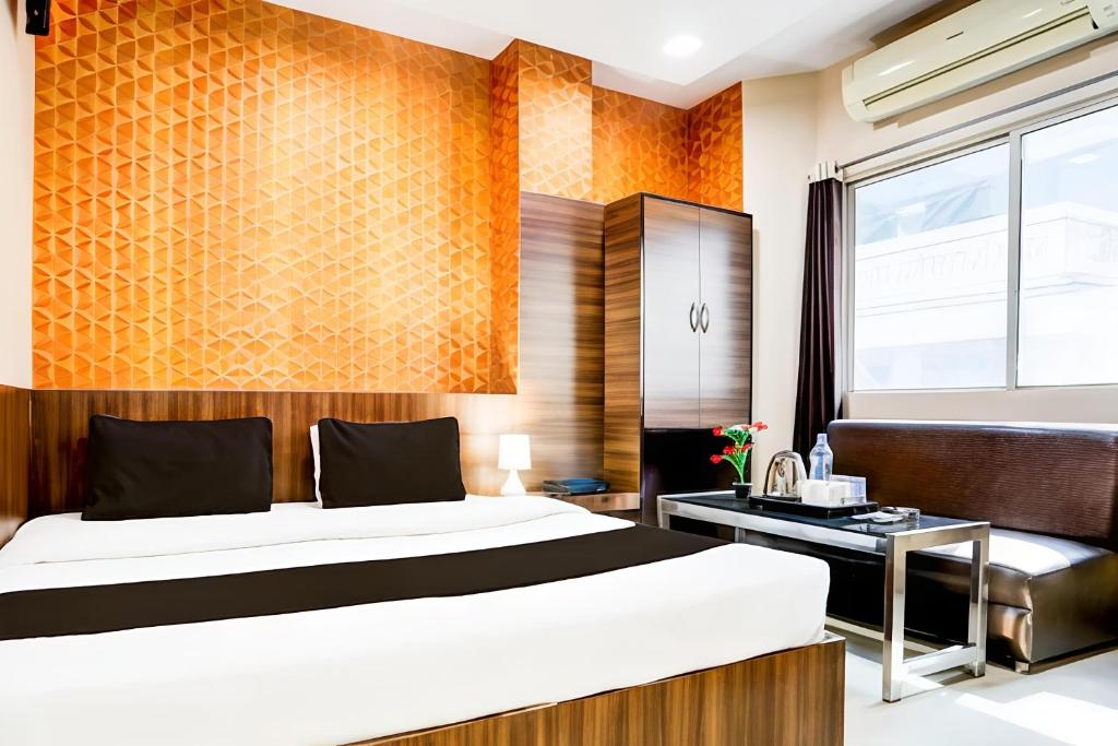 a bedroom with a large bed and a desk at Hotel Swarat by TruStay in Satna