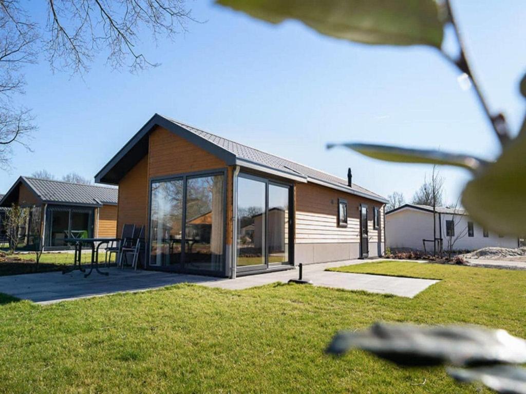 a house with large glass windows on a yard at Dog Friendly Chalet Kaatsheuvel in Kaatsheuvel