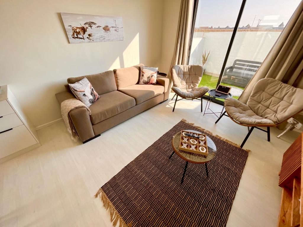 a living room with a couch and two chairs at 42 on Kavango Unit 24 in Swakopmund