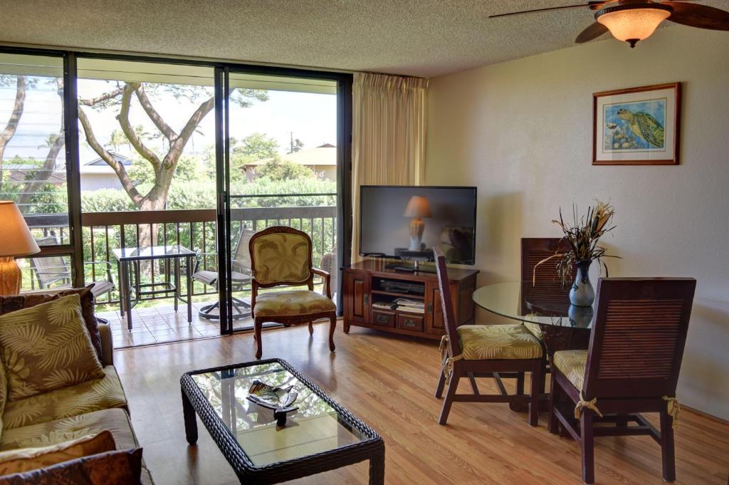 uma sala de estar com uma televisão e uma mesa e cadeiras em Maui Vista 2220 em Kihei