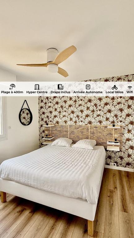 a bedroom with a large white bed with a wall at Hyper Centre - Draps Inclus - Fibré - Parking - Local Vélos - Jusqu'à 6 personnes in Saint-Brevin-les-Pins