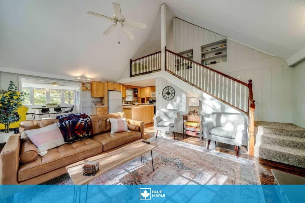a living room with a couch and a staircase at Fire Pit Arcade Games Deck Grill & Pool Access in Hedgesville