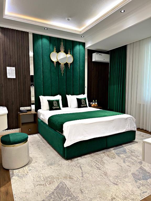 a bedroom with a large bed with a green wall at Qadim Hotel in Samarkand