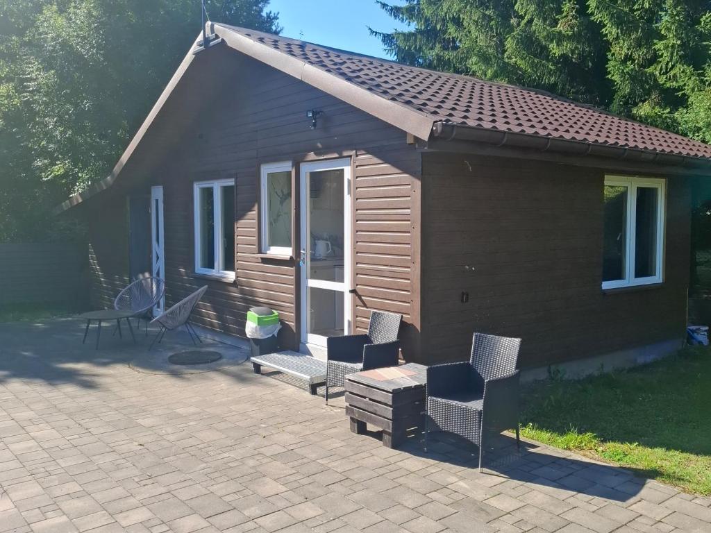 a small house with chairs and a patio at domek 3 osoobowy in Augustów