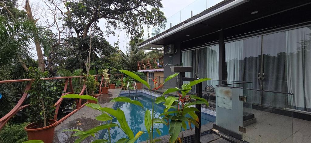 ein Haus mit Swimmingpool neben einem Gebäude in der Unterkunft Rustic Kraft in Porvorim