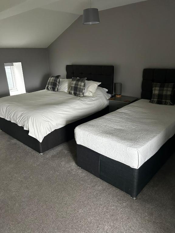 two beds sitting in a room with at Chevin End Guest House in Otley